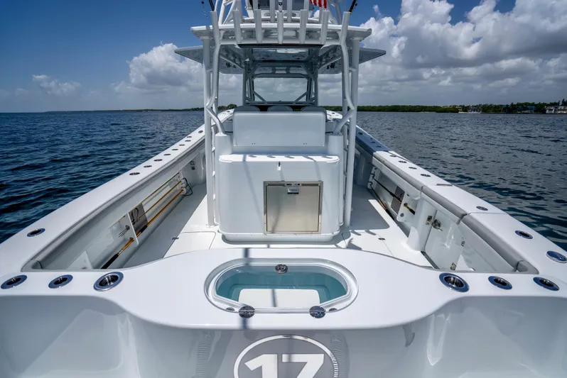  Yacht Photos Pics 2023 Yellowfin 42 Offshore boat on open water, showcasing spacious deck and sleek design.