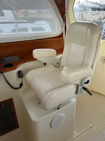  Yacht Photos Pics Captain's chair in 2001 Hinckley Classic 36 Picnic Boat cockpit, featuring beige leather upholstery.