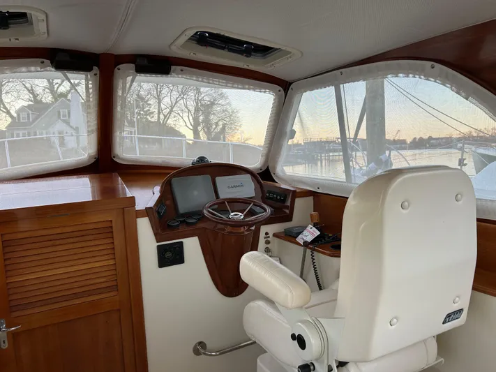  Yacht Photos Pics Helm of 2001 Hinckley Classic 36 Picnic Boat with white captain's chair and wooden dashboard.