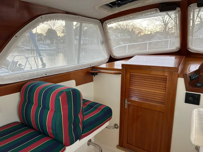  Yacht Photos Pics Interior of 2001 Hinckley Classic 36 Picnic Boat with striped seating and wooden cabinetry.