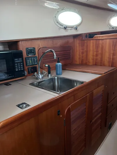  Yacht Photos Pics 2001 Hinckley Classic 36 Picnic Boat interior with wooden cabinetry and stainless steel sink.