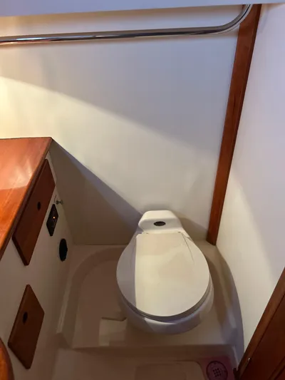  Yacht Photos Pics 2001 Hinckley Classic 36 Picnic Boat bathroom interior with wooden accents and compact toilet.
