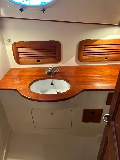  Yacht Photos Pics 2001 Hinckley Classic 36 Picnic Boat interior with wooden sink area and storage.