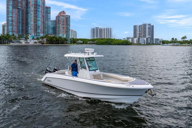My Sherry III Yacht Photos Pics 2018 Boston Whaler 280 Outrage cruising on water with city skyline backdrop.