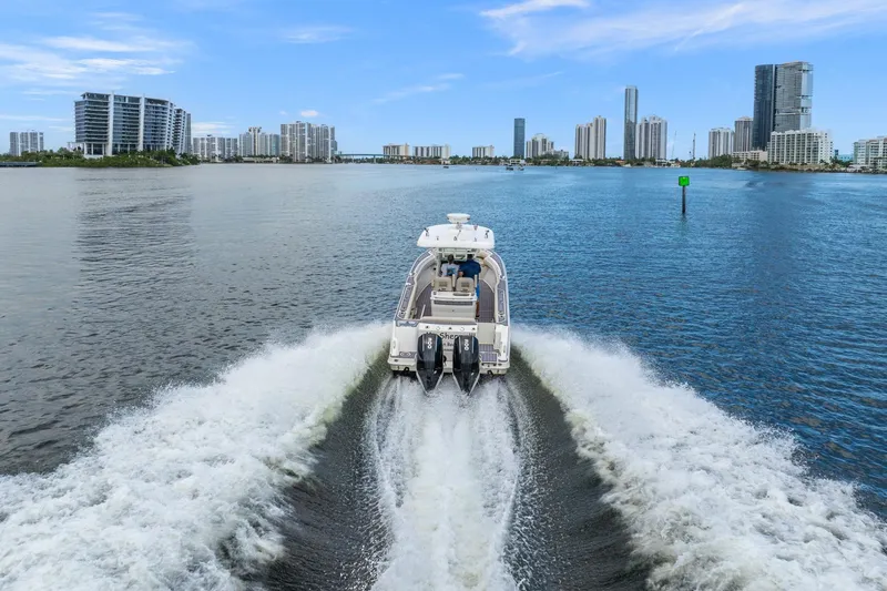 My Sherry III Yacht Photos Pics 2018 Boston Whaler 280 Outrage cruising in urban waterfront, city skyline in background.
