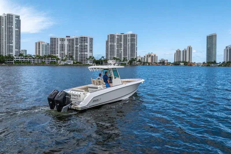 My Sherry III Yacht Photos Pics 2018 Boston Whaler 280 Outrage cruising near city skyline on calm water.