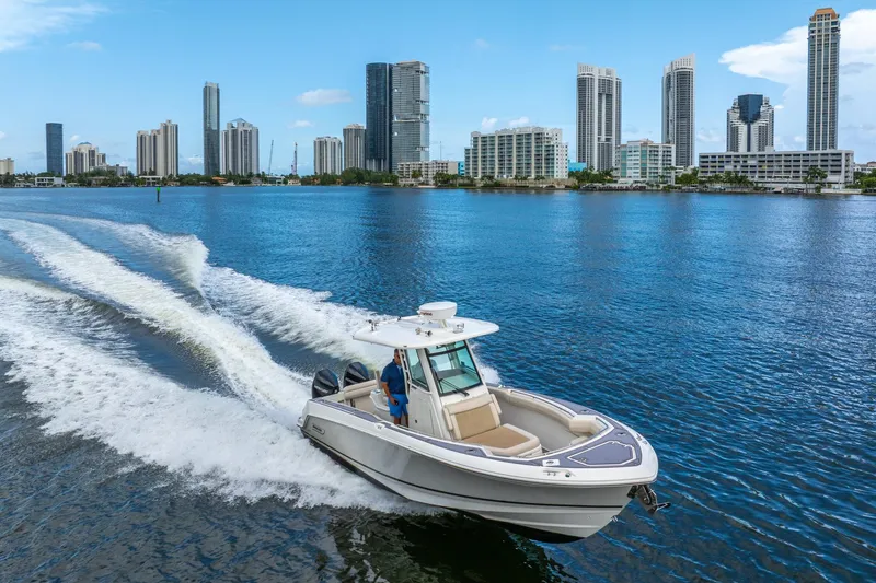 My Sherry III Yacht Photos Pics 2018 Boston Whaler 280 Outrage cruising on water with city skyline backdrop.