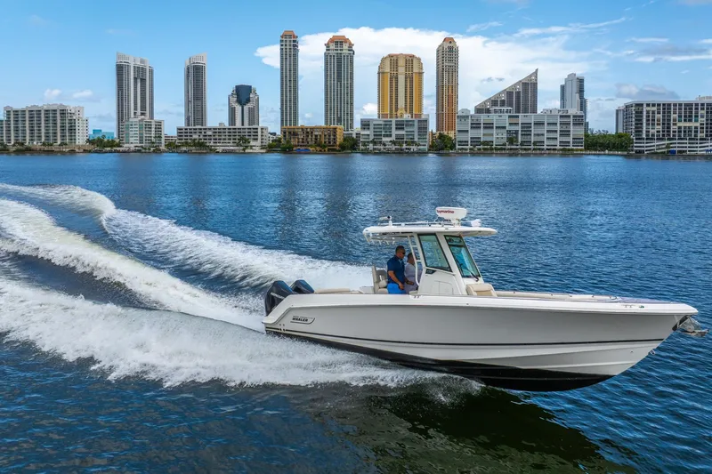 My Sherry III Yacht Photos Pics 2018 Boston Whaler 280 Outrage cruising on water with city skyline backdrop.