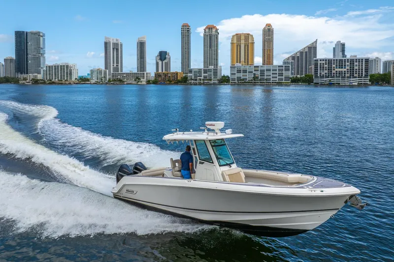My Sherry III Yacht Photos Pics 2018 Boston Whaler 280 Outrage cruising on water with city skyline in background.