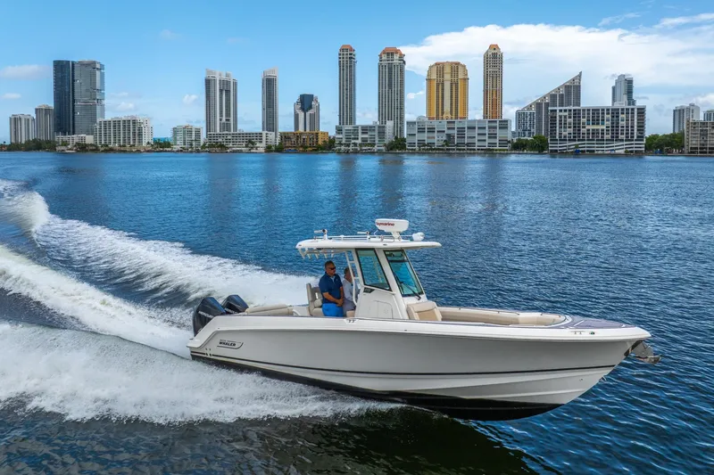 My Sherry III Yacht Photos Pics 2018 Boston Whaler 280 Outrage cruising on water with city skyline in background.