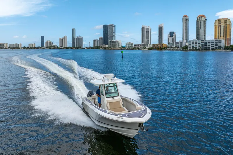 My Sherry III Yacht Photos Pics 2018 Boston Whaler 280 Outrage cruising near city skyline on a sunny day.