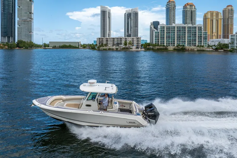 My Sherry III Yacht Photos Pics 2018 Boston Whaler 280 Outrage cruising on water with city skyline backdrop.