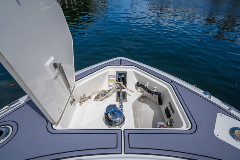 My Sherry III Yacht Photos Pics 2018 Boston Whaler 280 Outrage anchor compartment with open hatch, docked on calm water.