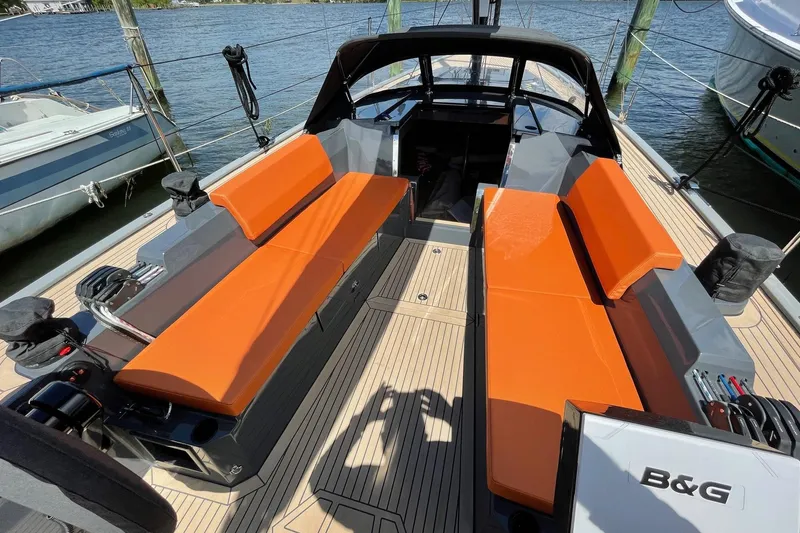 Saffire Yacht Photos Pics 2022 Saffier 33 Life sailboat with orange seating, docked by the water.