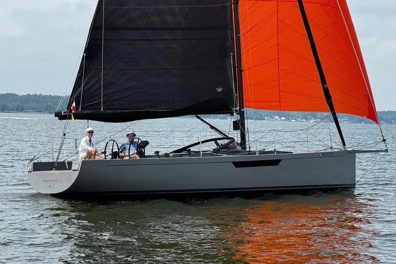 Saffire Yacht Photos Pics Saffier 33 Life 2022 sailboat with black and orange sails on calm water.