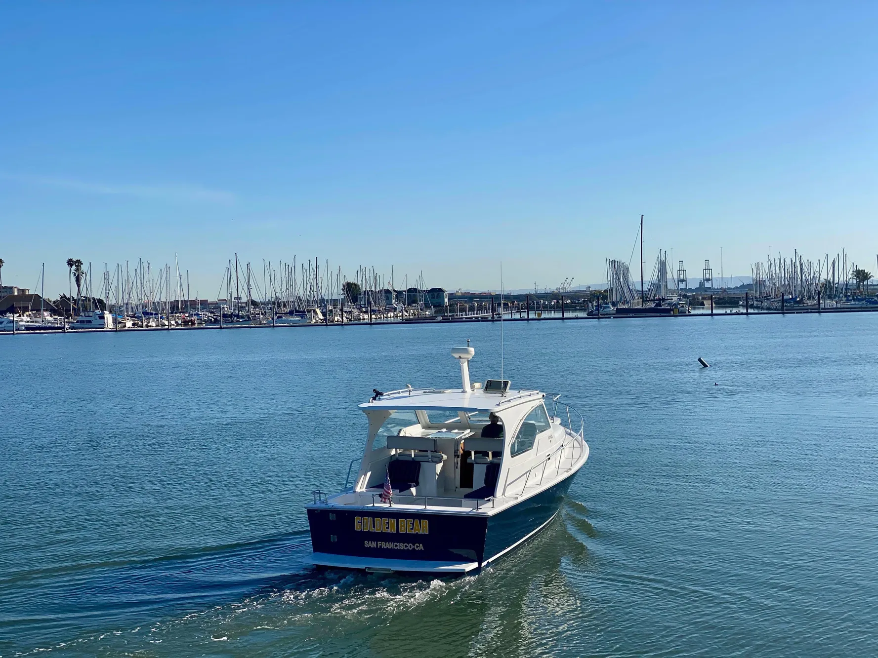 2000 Mainship Pilot 34 cruising on calm waters near marina.