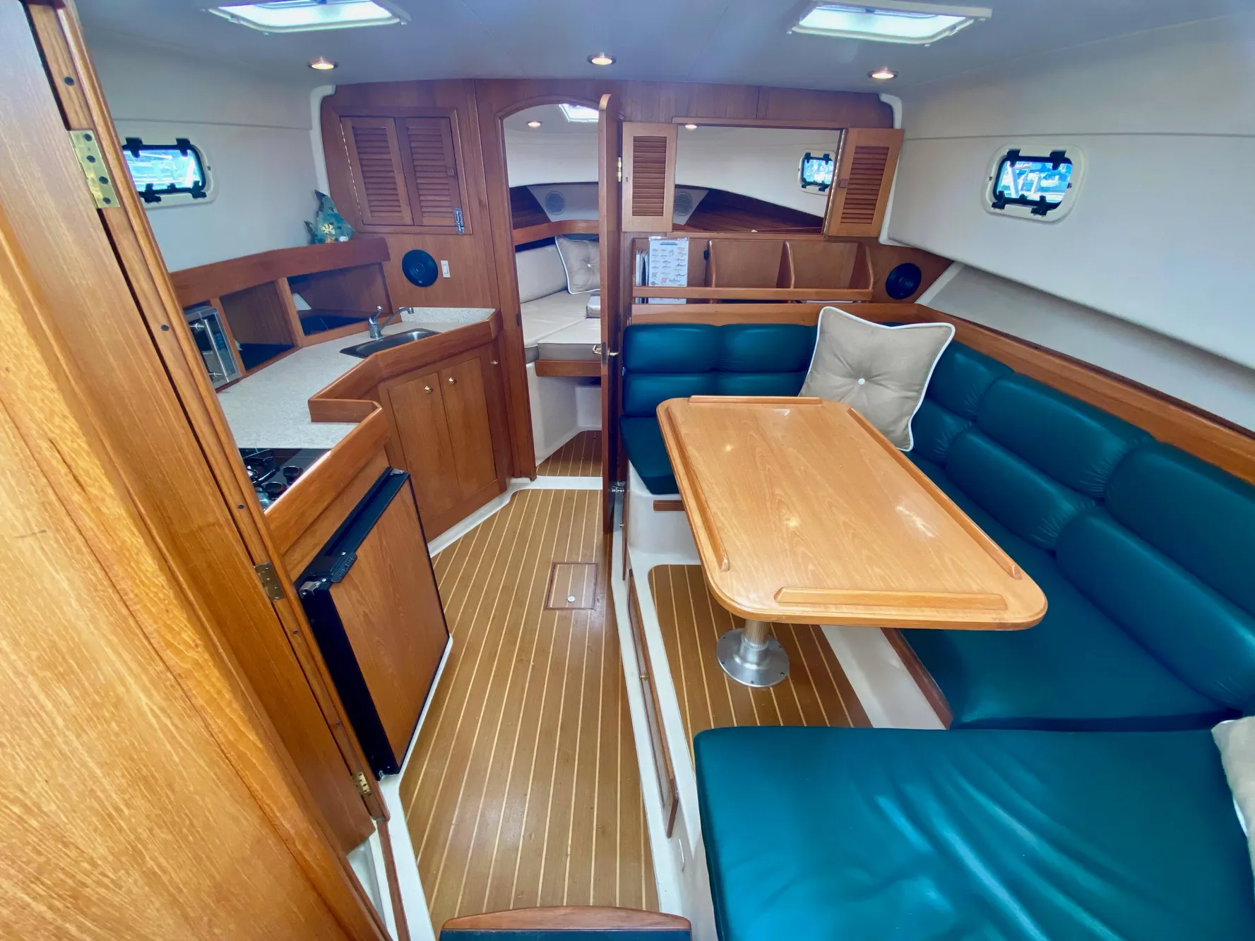 Interior of a 2000 Mainship Pilot 34 yacht with wood furnishings and blue upholstery.