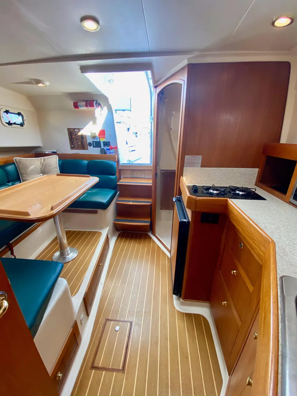 Interior of a 2000 Mainship Pilot 34 yacht with wood flooring and seating area.