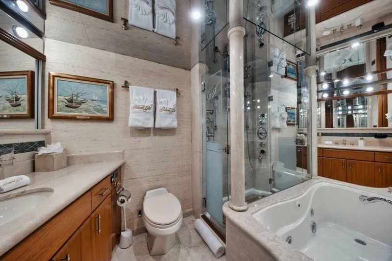 Island Girl Yacht Photos Pics Luxurious yacht bathroom with elegant fixtures, glass shower, and jacuzzi tub on 2002 Westport 112.