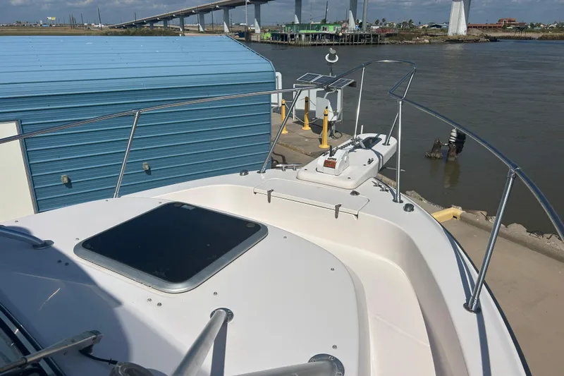  Yacht Photos Pics 2004 Grady-White Marlin 300 boat docked near a blue building and bridge.