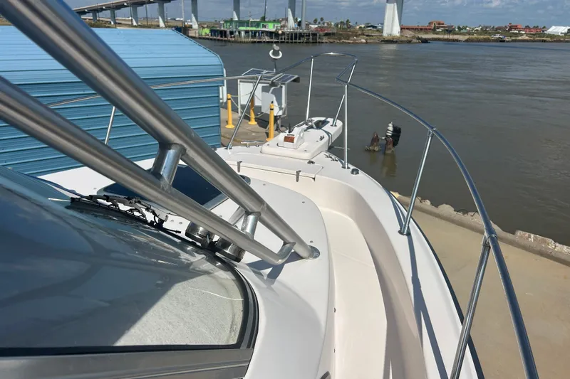  Yacht Photos Pics 2004 Grady-White Marlin 300 boat docked by a river with bridge in background.