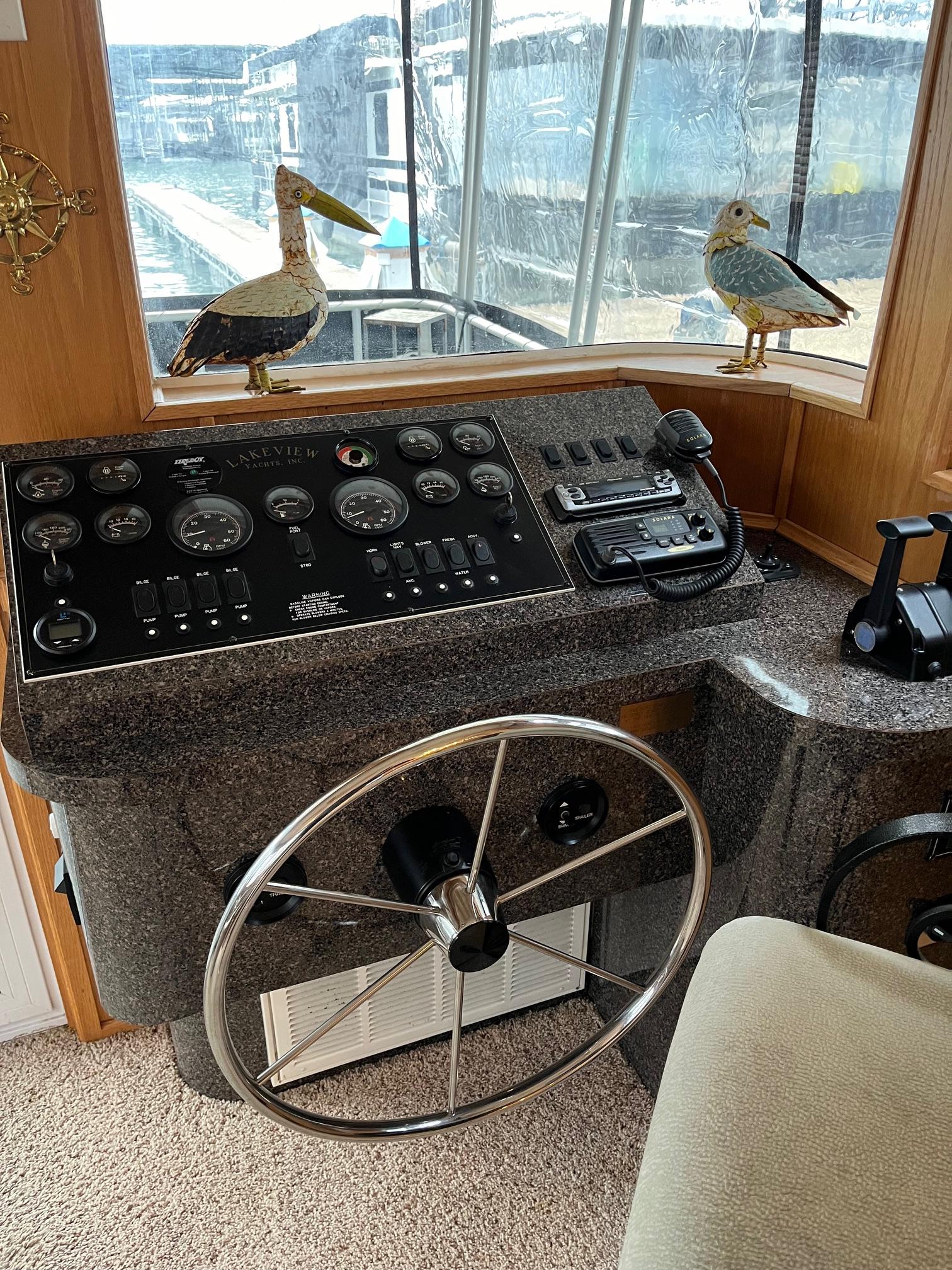 2003 Lakeview Houseboat helm with steering wheel and control panel.