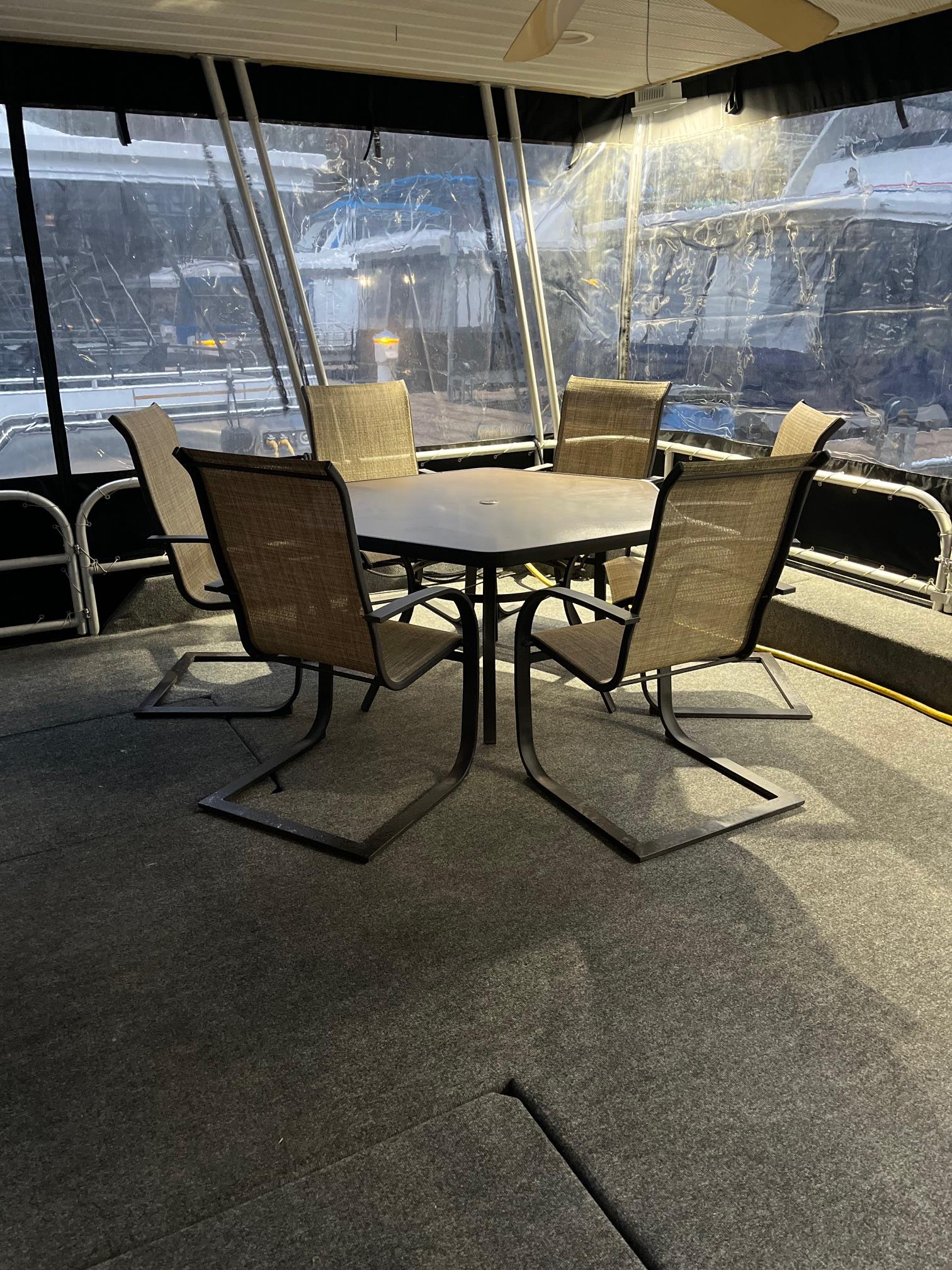 2003 Lakeview Houseboat interior with dining table and chairs on carpeted deck.