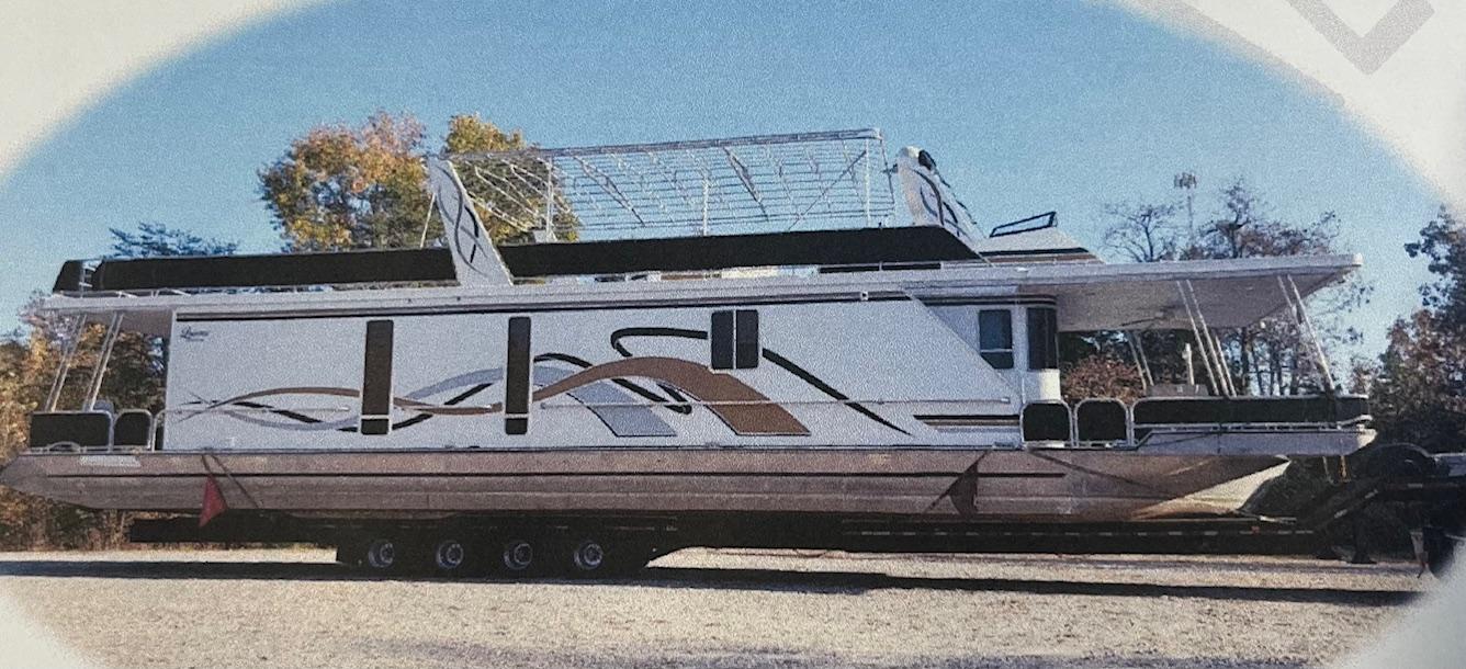 2003 Lakeview Houseboat on a trailer, parked outdoors with trees in the background.