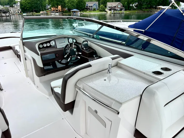  Yacht Photos Pics 2016 Regal 3200 Bowrider interior with helm, seating, and sink, docked by a lake.