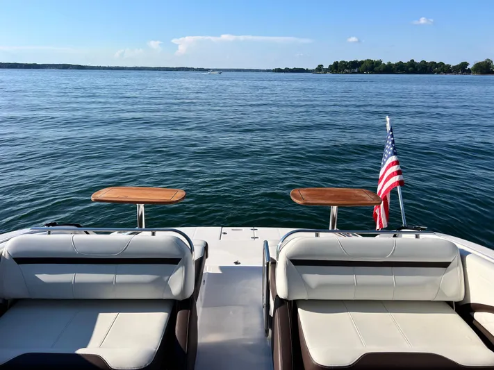  Yacht Photos Pics 2016 Regal 3200 Bowrider on calm lake with American flag and seating area.