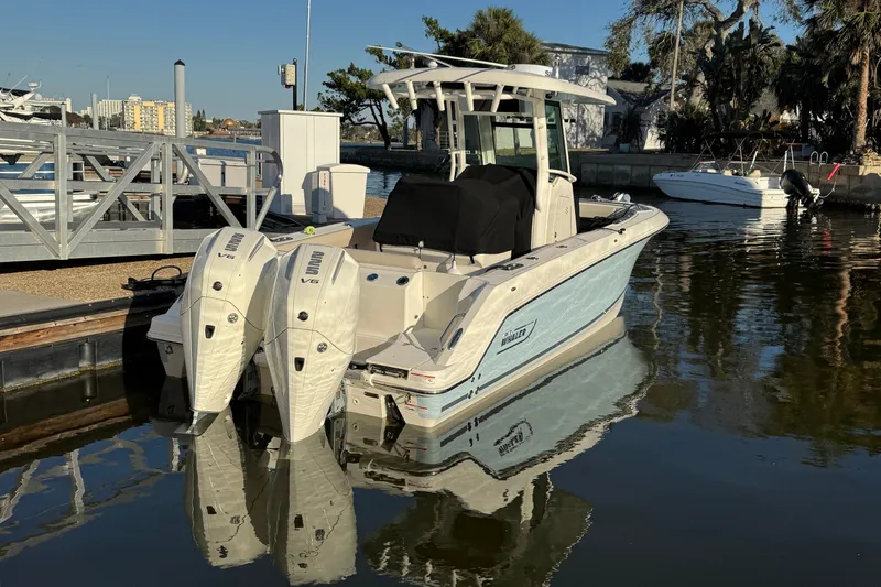  Yacht Photos Pics 2023 Boston Whaler 250 Outrage boat docked with twin engines, reflecting on calm water.