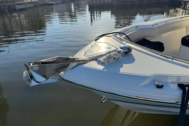  Yacht Photos Pics 2023 Boston Whaler 250 Outrage bow with anchor, docked on calm water.