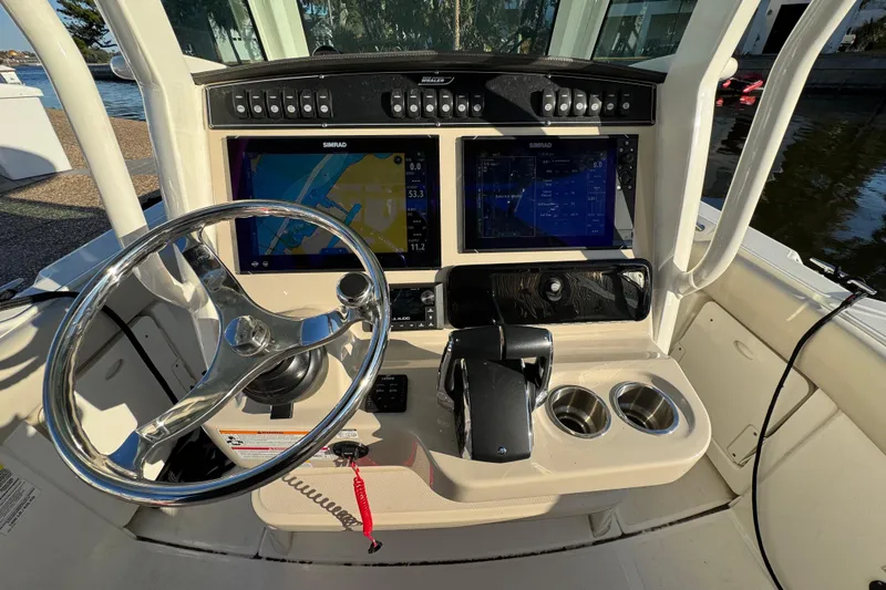  Yacht Photos Pics 2023 Boston Whaler 250 Outrage boat dashboard with steering wheel and navigation screens.