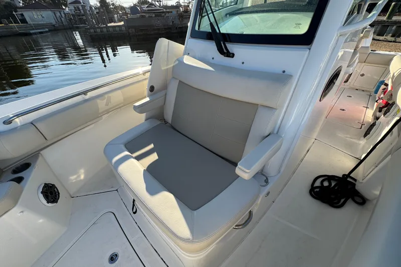  Yacht Photos Pics 2023 Boston Whaler 250 Outrage boat interior with cushioned seating and waterfront view.