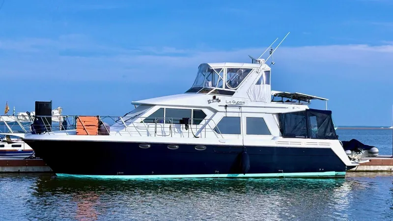 Lagypsie Yacht Photos Pics 1999 Navigator 4800 CLASSIC yacht docked in a serene marina setting.