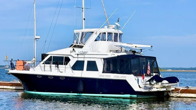 Lagypsie Yacht Photos Pics Navigator 4800 CLASSIC 1999 yacht docked on calm water under clear blue sky.