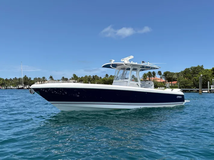 Agitator Yacht Photos Pics 2016 Intrepid 327 Center Console boat on clear blue water, sunny day.