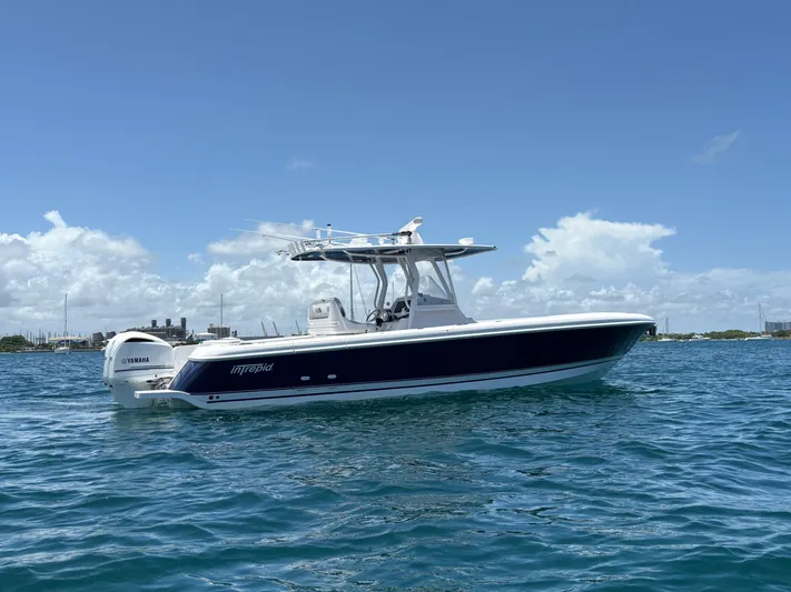 Agitator Yacht Photos Pics 2016 Intrepid 327 Center Console boat on blue ocean under clear sky.