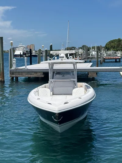 Agitator Yacht Photos Pics 2016 Intrepid 327 Center Console boat docked in a marina under clear blue skies.