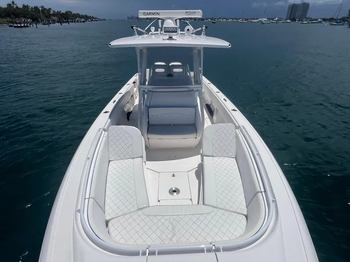 Agitator Yacht Photos Pics 2016 Intrepid 327 Center Console boat on calm water, featuring spacious seating and Garmin equipment.