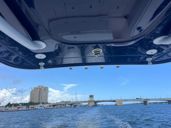 Agitator Yacht Photos Pics 2016 Intrepid 327 Center Console boat on water near a bridge and cityscape.