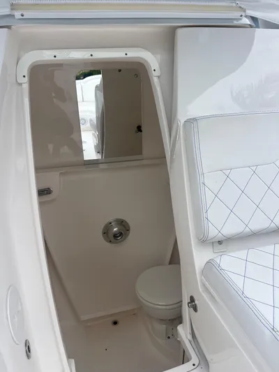 Agitator Yacht Photos Pics 2016 Intrepid 327 Center Console boat interior with compact marine toilet.