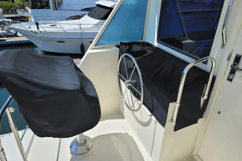 Southern Girl Yacht Photos Pics 1989 Hatteras Convertible yacht helm station with covered controls and steering wheel.