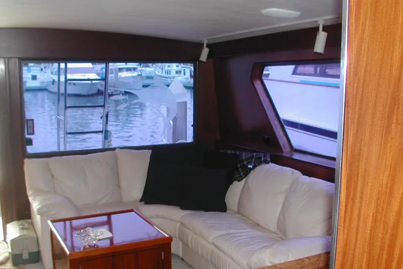 Southern Girl Yacht Photos Pics Interior of 1989 Hatteras Convertible yacht with white sofa and marina view.