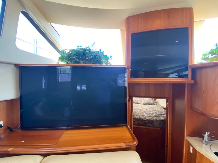 Aqua Holic Yacht Photos Pics Interior of 2002 Silverton 43 MY yacht with TV, cabinets, and bedroom view.