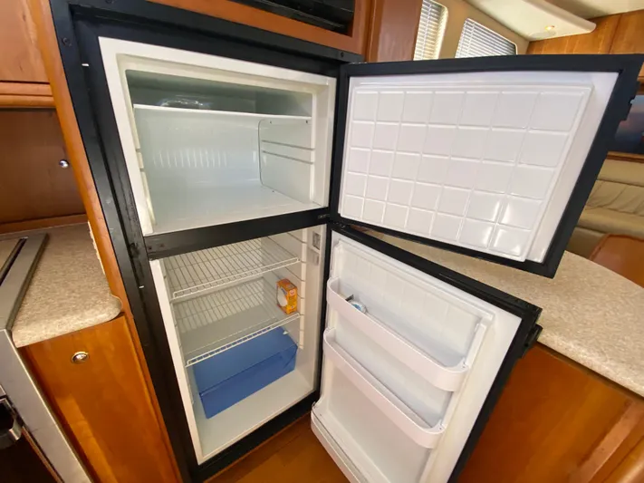 Aqua Holic Yacht Photos Pics Open refrigerator inside 2002 Silverton 43 MY yacht, showing shelves and door compartments.