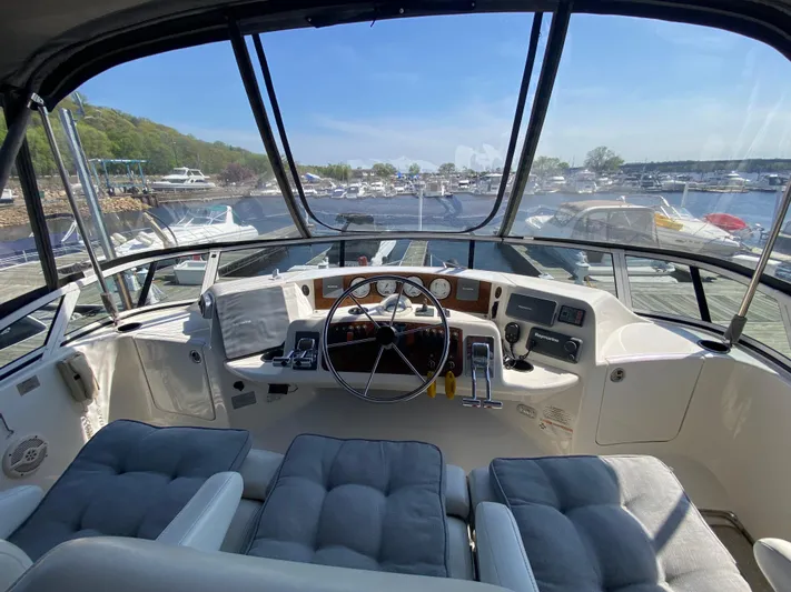 Aqua Holic Yacht Photos Pics Interior view of 2002 Silverton 43 MY yacht cockpit with marina background.