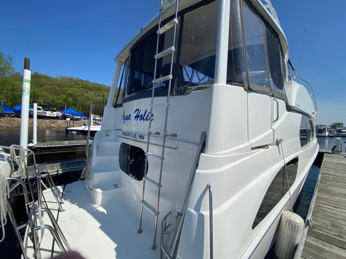 Aqua Holic Yacht Photos Pics 2002 Silverton 43 MY yacht docked, featuring sleek design and ladder access.