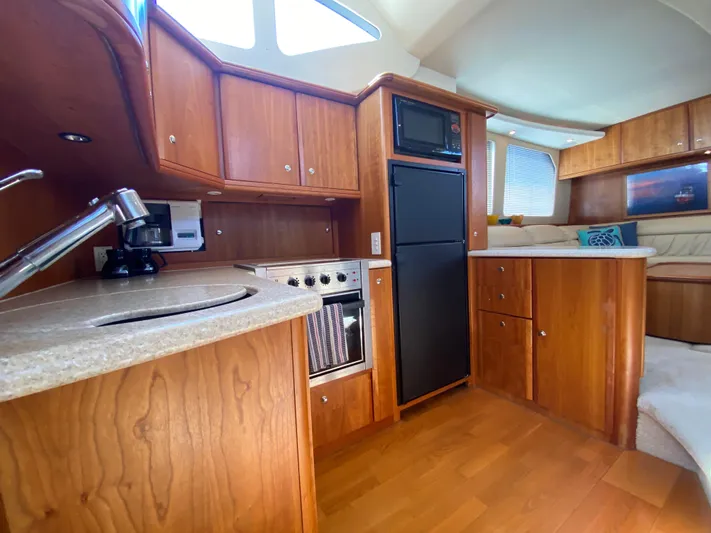 Aqua Holic Yacht Photos Pics Interior of 2002 Silverton 43 MY yacht with wooden cabinetry and modern kitchen amenities.