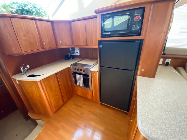 Aqua Holic Yacht Photos Pics 2002 Silverton 43 MY yacht kitchen with wood cabinets, microwave, and refrigerator.